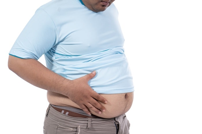 fat-man-pinching-excess-fat-around-his-waist-min